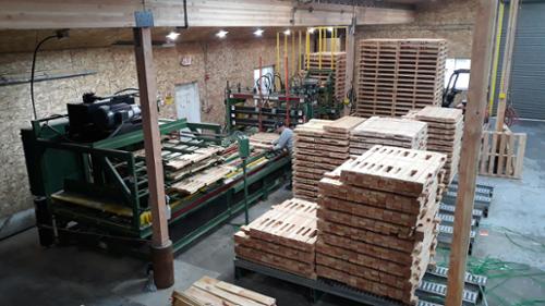 Pallet kits staged on conveyors at the pallet factory